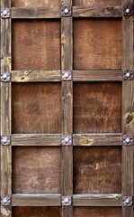 Old style brown wooden front door with wooden planks.