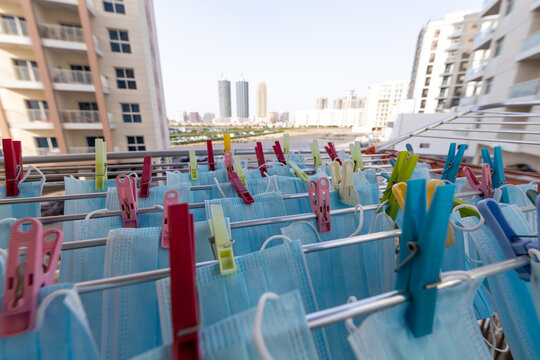 Blue Disposable Surgical Mask Washed And Hanging On A Drying Rack. Concept Of Shortage Of Personal Protection Equipment (PPE). Concept Of Re Usability And Recycling During Crisis Times.