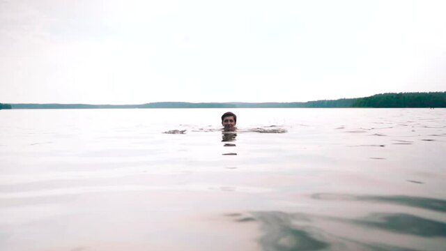Girl swimming underwater in a lake, soft waves n ripples on the water surface.