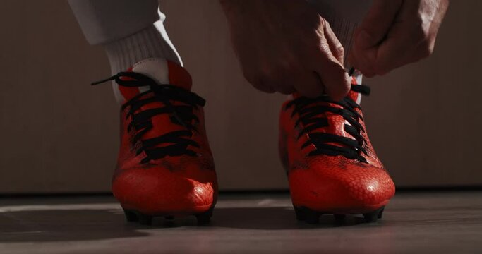Detail shot of a professional soccer football player put on his shoes. 4k