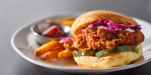 crispy fried chicken sandwich on plate with fries - Powered by Adobe