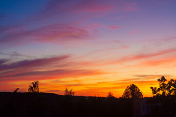 Natural sunset. Bright dramatic sky with clouds. Countryside in Belarus. Picturesque colorful sky at sunset.
