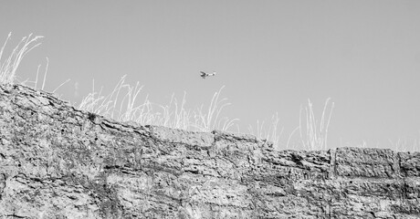 Obraz premium An airplane fly above the wall of the medieval fortress Koporye