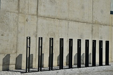 Modern metal bicycle stand near the concrete wall. Bicycle parking at the commercial building.