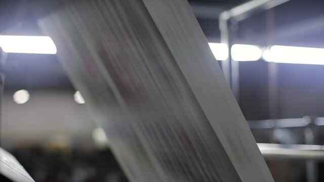 Blurry newspapers in a printing press production lane.