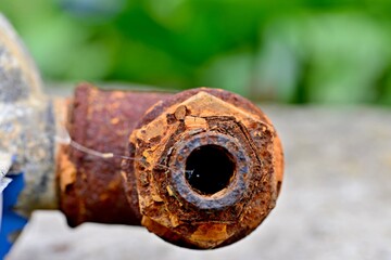 Rusty elbow on an old electric water pump. Rusted pipes.