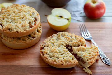 Pieces of delicious apple pie on wooden background