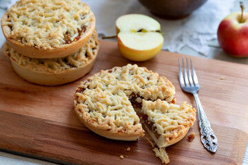 Pieces of delicious apple pie on wooden background