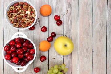 Healthy breakfast with ingredients, summer fruits and berries with granola, grapes, cherries and peaches on a bright table. The concept of a healthy and natural diet, lifestyle, flat lay
