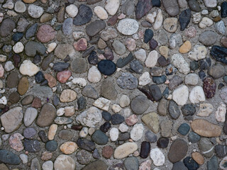 kleine Steine eingelassen in Beton, Hintergrund, grafisches Element, abstraktes Muster 