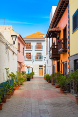 Fototapeta na wymiar Colorful buildings on a narrow street in spanish town Punto Brava on a sunny day, Tenerife, Canary islands, Spain.
