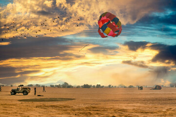 Jeep towing a parachute for adventure para gliding in the empty barren thar desert in rajasthan...