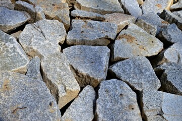 Stone riverbed. Area of stacked stones. Top view of stacked granite blocks.