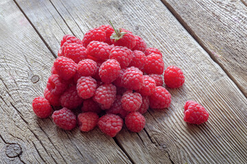 red, juicy, ripe raspberries on an old wooden background, summer season of fresh berries, natural...