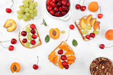 Diet fruit sandwiches with cottage cheese, peaches, grapes and cherries, a healthy breakfast with ingredients. The concept of a healthy and natural meal, lifestyle, flat lay