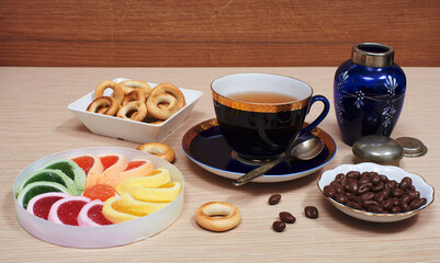 Cup of tea, fruit jelly, chocolate covered raisins, ring-shaped cracknel