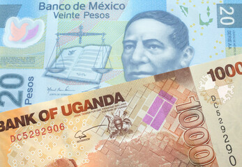 A twenty peso note from Mexico with a one thousand Ugandan shilling bill close up in macro