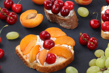 Diet fruit toasts with cottage cheese, peaches, grapes and cherries, healthy breakfast with ingredients. The concept of healthy and natural food, lifestyle, flat lay, place for text
