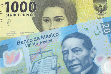 An green one thousand Indonesian rupiah bank note with a twenty peso note from Mexico