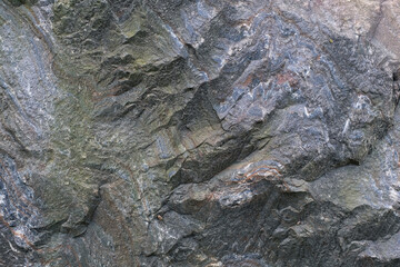 Stone wall background. Rough surface of a old granite boulder. Abstract pattern of raw granite. Stone texture for use of background. Selective focus