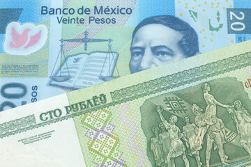 A close up image of a twenty peso note from Mexico with a one hundred ruble note from Belarus