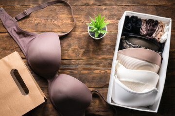 Female underwear and shopping bag on a wooden table background.