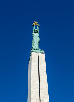 Copper figure of Liberty at the top of the Freedom Monument in Riga, Latvia. It is a 9 meters woman lifting three gilded stars, symbolizing the districts of Latvia: Vidzeme, Latgale and Courland.