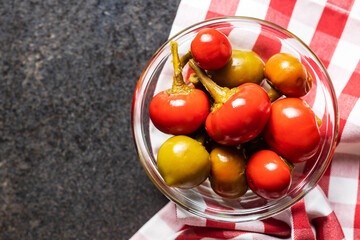 Round chili peppers. Green and red pickled peppers.
