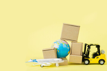 Fototapeta premium Mini forklift truck load cardboard boxes in the Airplane. Fast delivery of goods and products. Logistics, connection to hard-to-reach places. Banner, copy space