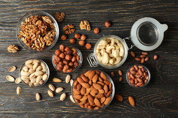 Bowls with different nuts on wooden background. Vitamin food