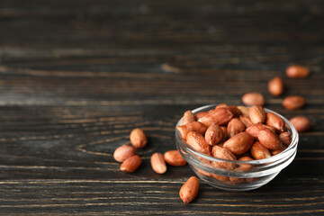 Bowl with peanut on wooden background. Vitamin food