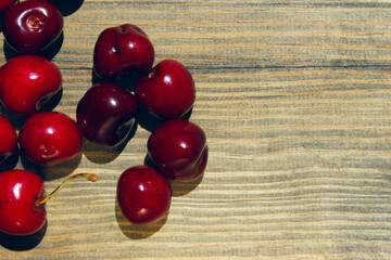 Red cherry berries on a wooden background. Cherry on the table. Abstract food background.