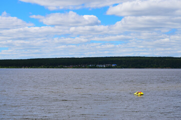 people on a catamaran swim on the river to the other bank summer vacation in nature