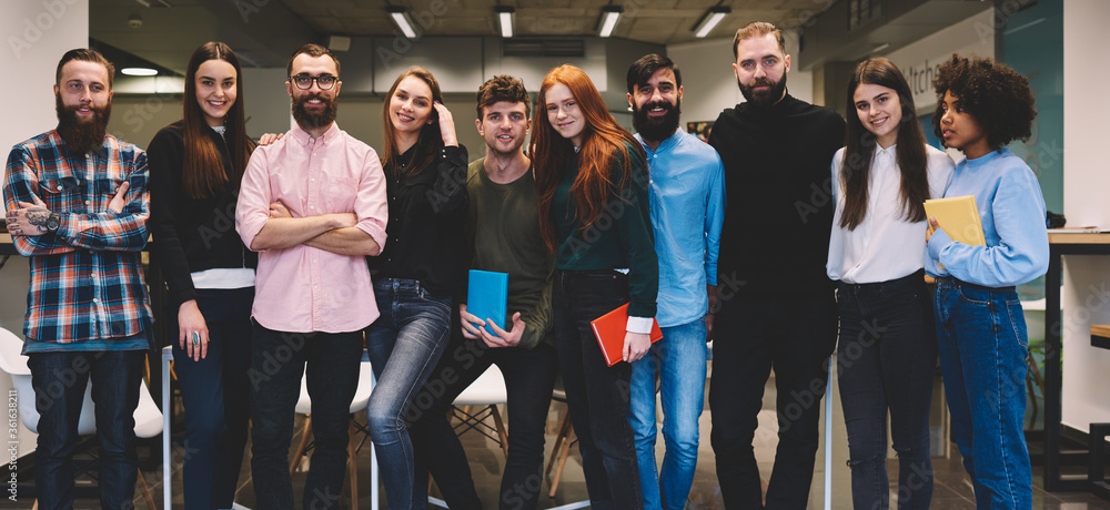 Poster full length portrait of international designers looking at camera and smiling while standing in mode