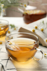 Composition with chamomile tea on white wooden background