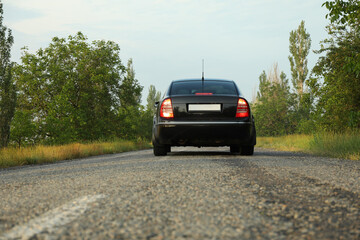 Fototapeta na wymiar Black car on asphalt road. Travel. Summer vacation