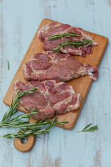 Raw fresh meat steak entrecote, rosemary and seasonings on a cutting board.
