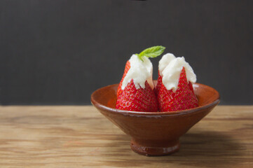 Strawberries with cream on black background and copy space