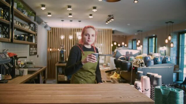 A young Barista Girl Makes delicious coffee. Coffee shop worker with a modern hairstyle, Fashionable Barista, Modern gir