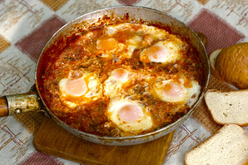 shakshuka - jewish national dish with fried eggs species, tomato, pepper garlic