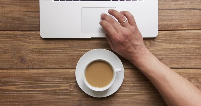 Top view of man work on laptop and drink coffee with milk