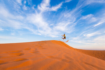 Naklejka na ściany i meble Young man on Red sand dunes in Vietnam