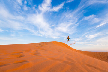 Fototapeta na wymiar Young man on Red sand dunes in Vietnam