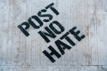 Post No Hate, NYC graffiti stencil type message spray painted over the sidewalk street.