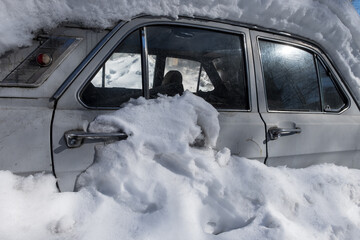 Obraz premium Extreme snowfall. Old fashioned car buried under snow
