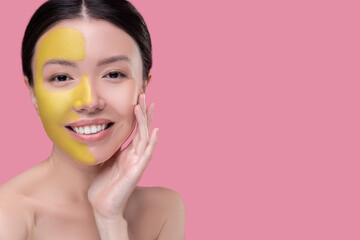 Woman having a facial mask on half of her face