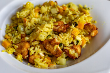 paella with meat, pepper, vegetables and spices on dish
