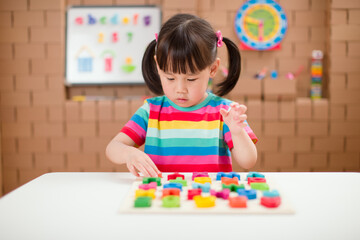 toddler girl learning letter blocks for homeschooling