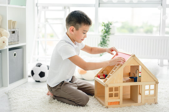 Cute Little Boy Playing With Dollhouse