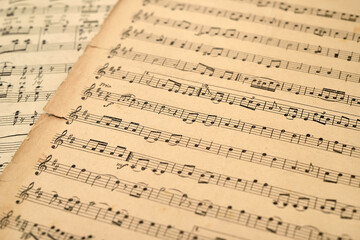 Fototapeta premium Fragment of old grunge sheets with music notes. Close-up. Retro style. Selective focus.